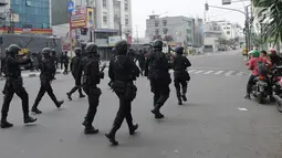 Personel Brimob mengusir massa usai terjadi pembakaran bus milik Brimob Polda Metro Jaya di kawasan Jalan Brigjend Katamso, Slipi, Jakarta, Rabu (22/5/2019). Selain dua bus milik Brimob, tiga bus dan satu mobil lainnya juga rusak berat akibat dilempari batu oleh massa. (merdeka.com/Arie Basuki)