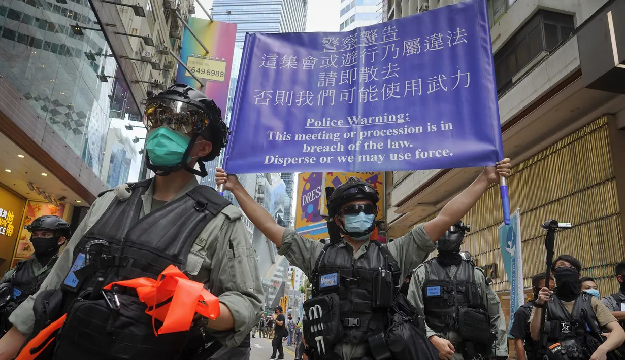 Polisi memajang spanduk peringatan kepada pengunjuk rasa yang menentang Undang-Undang Keamanan Nasional di Causeway Bay sebelum pawai penyerahan tahunan di Hong Kong, Rabu (1/7/2020). Hong Kong menandai peringatan 23 tahun penyerahannya ke China pada tahun 1997. (AP Photo/Vincent Yu)