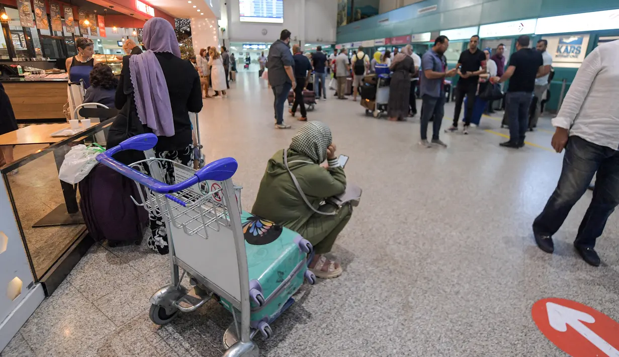 Calon penumpang menunggu dengan barang bawaan mereka setelah penerbangan dibatalkan karena aksi mogok massal pekerja di Bandara Internasional Tunis-Carthage Tunisia, Kamis (16/6/2022). Serikat Pekerja Umum Tunisia (UGTT) mengadakan aksi mogok massal pada hari Kamis ini menuntut kenaikan gaji dan konsesi. (FETHI BELAID / AFP)