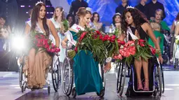 Miss Belarus Aleksandra Chichikova (tengah) terpilih sebagai Miss Wheelchair World di Warsawa, Polandia, Sabtu (7/10). Para kontestan berlaga dengan membawakan baju nasional, gaun cocktail dan gaun malam juga menampilkan tarian. (Wojtek Radwanski/AFP)