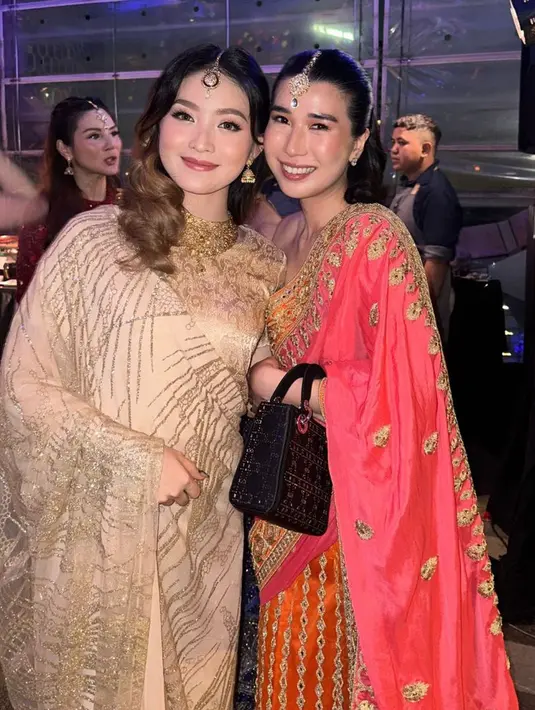 Natasha Wilona mengenakan busana warna gold kecoklatan dengan riasan kepala dan aksesori kalung dan antingnya. Penyanyi Christie tampil dengan sari warna orange berbordir warna keemasan. [@christie]