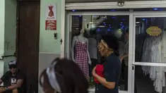 Warga berjalan melewati toko pakaian pribadi yang tutup di Havana, Kuba, Sabtu, 11 November 2023. (AP Photo/Ramon Espinosa)