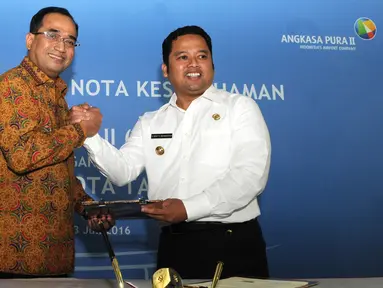 Presdir AP II, Budi Karya Sumadi dan Walikota Tangerang Arief R Wismansyah berjabat tangan usai penandatanganan nota kesepahaman mengenai suplai air bersih dan siap minum di Bandara Soekarno-Hatta, Tangerang, Rabu (13/7). (Liputan6.com/Helmi Affandi)