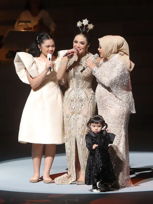 KD dan dua anaknya mengenakan dress serupa, sedangkan penampila Baby Ameena pun membuat gemas banyak orang. Anak pertama Aurel dan Atta Halilintar itu tampil menggemaskan dengan dress hitam dan rambut dikuncir dua. [Foto; Bambang E Ros/Fimela.com]