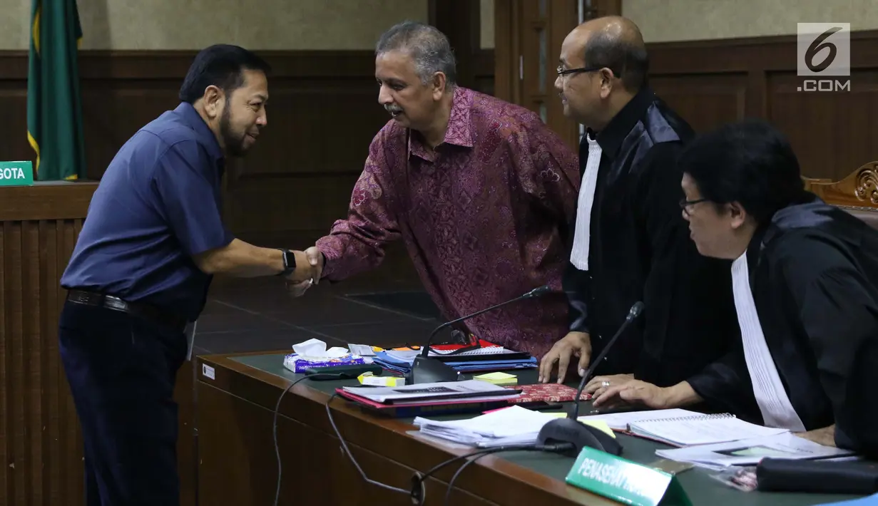 Terpidana korupsi e-KTP, Setya Novanto (kiri) menyalami terdakwa kasus dugaan suap proyek PLTU Riau-1 yang juga mantan Dirut PLN, Sofyan Basir usai menjadi saksi di Pengadilan Tipikor, Jakarta, Senin (12/8/2019). Sidang mendengar keterangan saksi. (Liputan6.com/Helmi Fithriansyah)