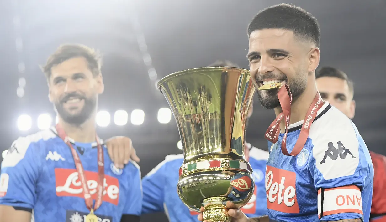 Pemain Napoli Lorenzo Insigne memegang trofi setelah timnya mengalahkan Juventus pada final Coppa Italia di Olympic Stadium, Roma, Italia, Rabu (17/6/2020). Napoli menjadi juara Coppa Italia 2019-2020 setelah mengalahkan Juventus lewat drama adu penalti. (Filippo MONTEFORTE/AFP)