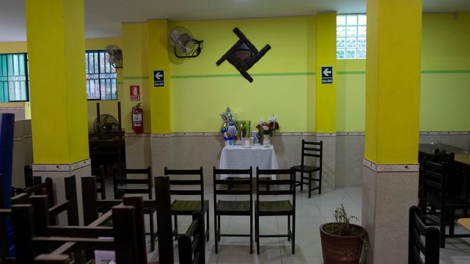 Altar untuk menghormati Wilfredo Davila Minano - korban COVID-19 - terlihat di restoran ceviche yang dimilikinya (saat ini tutup) di Trujillo, Peru, 23 Juni 2020. Hingga 25 September 2020, kematian global akibat COVID-19 hampir mencapai satu juta, sepertiganya di Amerika Latin. (Celso Roldan/AFP)