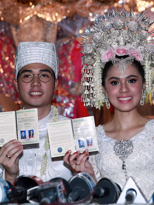 Akad nikah Nycta Gina dan Rizky Kinos. Pasangan yang telah resmi menjadi suami istri ini menunjukkan buku nikah mereka.  (Deki Prayoga/Bintang.com)