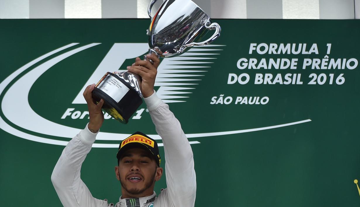 Pebalap Mercedes GP, Lewis Hamilton, menjaga asa untuk mempertahankan gelar juara dunia F1. Ini berkat kemenangan pada balapan F1 GP Brasil, Minggu (13/11/2016), dengan mengalahkan rivalnya, Nico Rosberg. (AFP/Miguel Schincariol)
