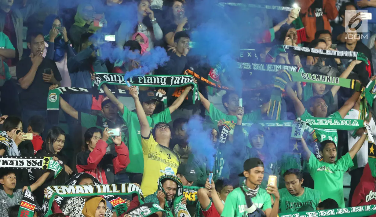 Suporter tim Elang Jawa menyalakan bom asap usai menyaksikan laga uji coba Timnas Indonesia u-19 melawan PSS Sleman di Stadion Maguwohardjo, Sleman, Sabtu (12/8). Laga ini persiapan Timnas sebelum Piala AFF U-18, Myanmar. (Liputan6.com/Helmi Fithriansyah)