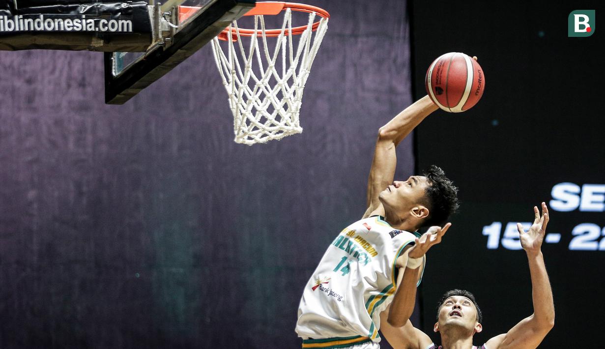 Pemain Satya Wacana Salatiga, Randy Ady Prasetya (kiri) berusaha memasukkan bola saat laga lanjutan Seri 1 IBL 2022 melawan Bali United Basketball di Hall Basket GBK, Senayan, Kamis (20/01/2022). (Bola.com/Bagaskara Lazuardi)