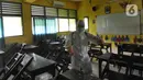 Petugas Palang Merah Indonesia (PMI) melakukan penyemprotan disinfektan di SMPN 216 Jakarta, Senin (16/3/2020). Mulai hari ini, aktivitas sekolah di sejumlah wilayah Indonesia diliburkan untuk mengantisipasi penyebaran virus corona COVID-19. (merdeka.com/Arie Basuki)