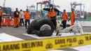 File foto pada 5 November 2018 memperlihatkan petugas menyemprot cairan pada bagian roda pesawat Lion Air PK-LQP JT 610 di Pelabuhan JICT 2, Jakarta. Bagian tersebut dipindah untuk dilakukan identifikasi dan pengecekan lebih lanjut oleh KNKT. (Liputan6.com/Helmi Fithriansyah)