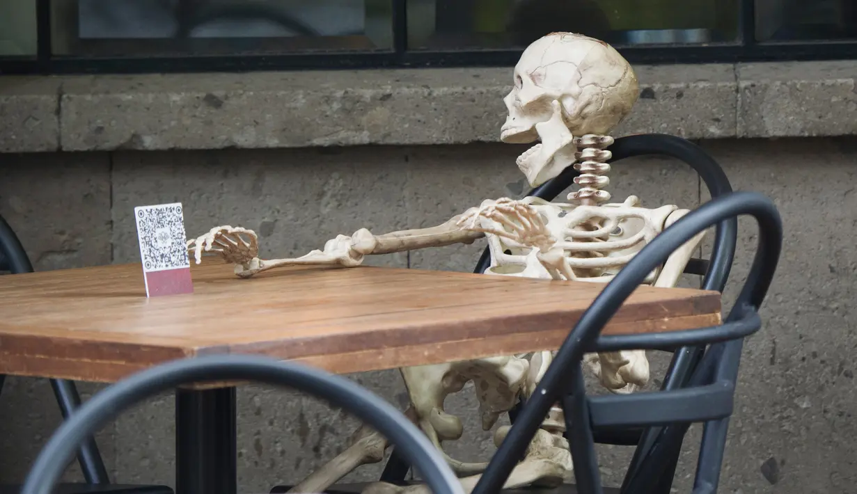Pemandangan yang disebut Calaca (sosok tengkorak atau kerangka), yang biasa digunakan untuk dekorasi selama Day of the Death, di sebuah restoran di Coyoacan, Mexico City, Selasa (20/10/2020). Restoran tersebut menggunakan tengkorak untuk menjaga jarak di tengah pandemi COVID-19. (CLAUDIO CRUZ/AFP)