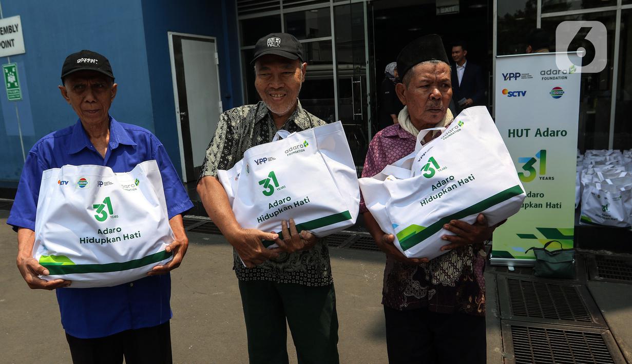 Warga membawa sembako yang di bagikan oleh PT Adaro Energi Tbk bersama Yayasan Pundi Amal Peduli Kasih (YPP) SCTV dan Indosiar di Jakarta, Rabu (4/10/2023). Dalam rangka Hari Ulang Tahun (HUT) Adaro ke-31 dengan tema “Adaro Hidupkan Hati” membagikan sembako sebanyak 2.000 paket  kepada masyarakat yang betul-betul memerlukan yang saat ini kurang beruntung di tengah beberapa harga sembako yang alami kenaikan. (Liputan6.com/Angga Yuniar)