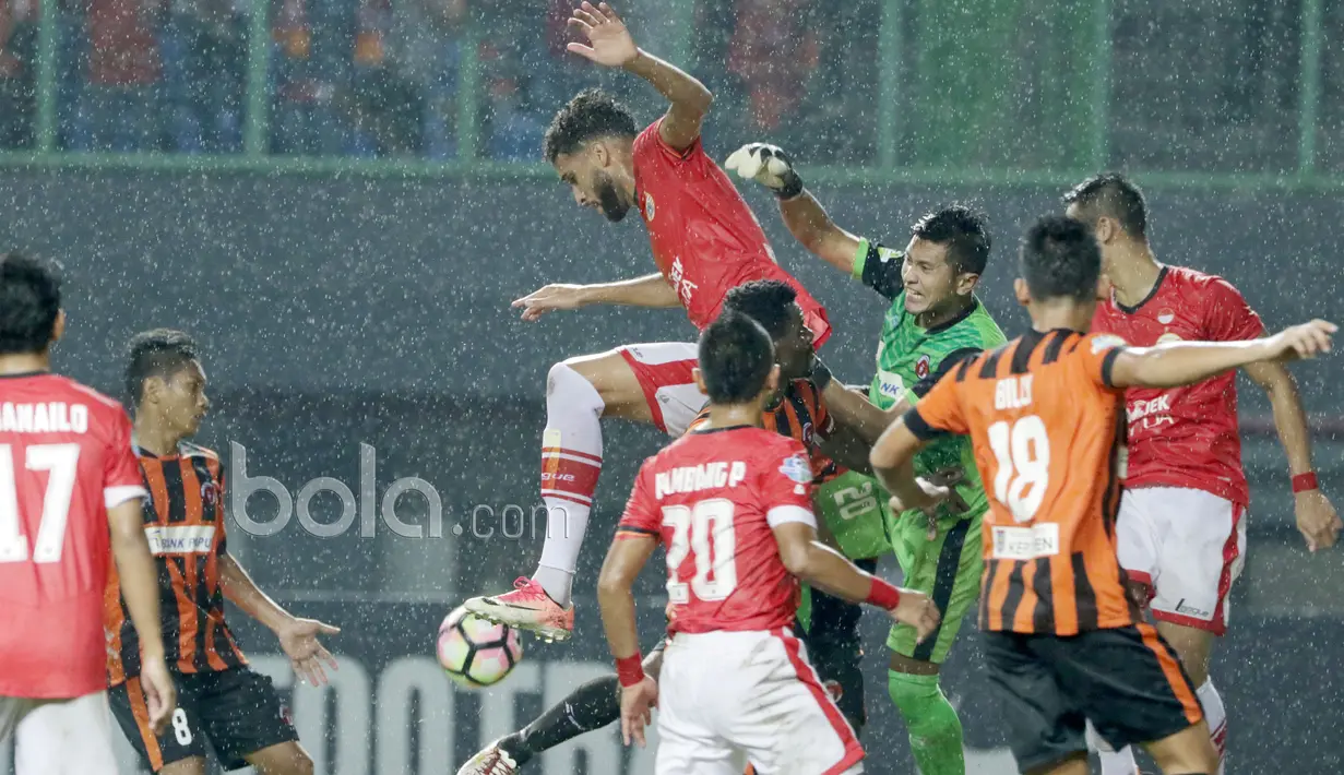 Kiper Perseru Serui, Sukasto Efendi berusaha menghalau bola dari sundulan pemain Persija Jakarta, Willian Pachecho  pada Liga 1 2017 di Stadion Patriot, Bekasi,(13/6/2017). Persija menang 3-0. (Bola.com/Nicklas Hanoatubun)