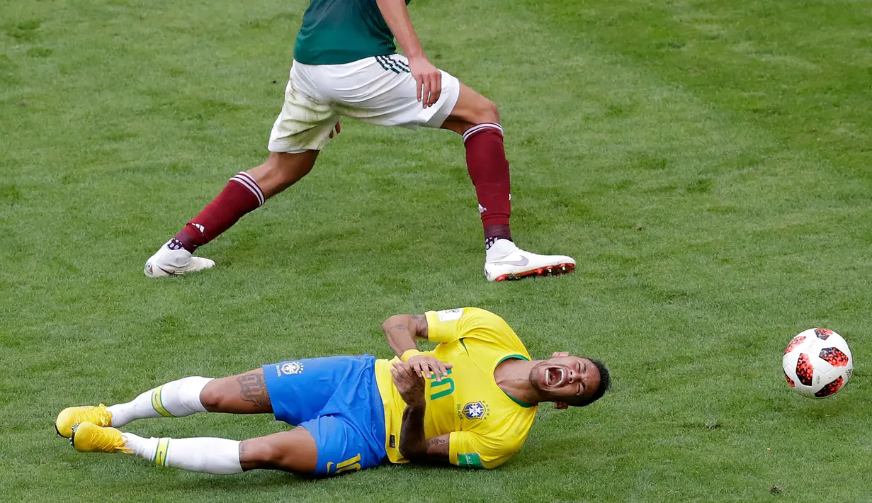 Penyerang timnas Brasil, Neymar mengerang kesakitan di atas lapangan pada babak 16 besar Piala Dunia 2018 melawan Meksiko di Samara Arena, Senin (2/7). Neymar memang menjadi bintang saat Brasil mengalahkan Meksiko 2-0. (AP/Sergei Grits)