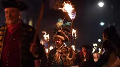 Peserta melakukan pawai melintasi jalan dalam perayaan Bonfire Night di Sussex Timur, Inggris, Selasa (5/11/2019). Setiap tahunnya pada tanggal 5 November, warga Inggris menggunakan kostum, berdandan, berkumpul, lalu melakukan pawai ke seluruh penjuru kota sambil membawa obor. (Ben STANSALL/AFP)