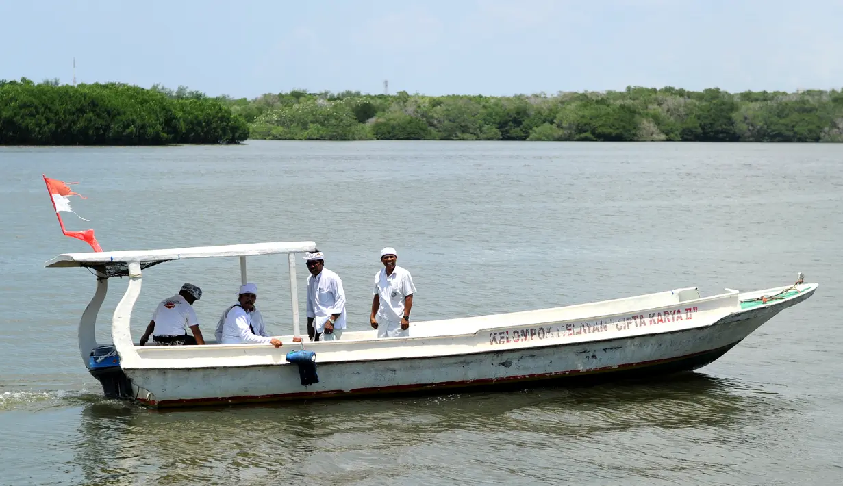 Umat Hindu menaburkan bunga di sebuah sungai selama perayaan Kuningan di Pulau Serangan, Denpasar, Bali, Sabtu (20/2). Kuningan merupakan hari terakhir dari perayaan Galungan. (AFP PHOTO/SONNY Tumbelaka)