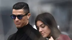 Cristiano Ronaldo bersama Georgina Rodriguez setelah menghadiri sidang pengadilan untuk penggelapan pajak di Madrid pada 22 Januari 2019. Dalam unggahan itu, Ronaldo mengungkap bahwa salah seorang dari bayi kembarnya selamat. Bayi itu berjenis kelamin perempuan. (AFP/OSCAR DEL POZO)