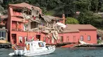 Sebuah perahu penjaga pantai menuju gedung bersejarah yang rusak di pantai Bosphorus, Istanbul, Turki (7/4). Gedung Hekimbasi Salih Efendi itu rusak berat usai ditabrak kapal tanker. (AFP Photo/Gurcan Ozturk)