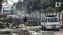 Pekerja mengerjakan proyek rivitalisasi jalan di kawasan Kota Tua, Jakarta Barat, Senin (17/5/2022). Revitalisasi difokuskan bagian Trotoar yang nantinya akan diperlebar menjadi tiga meter sehingga cukup luas untuk para pejalan kaki. Dan juga akan dilengkapi dengan ubin pengarah (guidingblock) serta jalur khusus sepeda. (Liputan6.com/Johan Tallo)