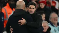 Manajer Manchester City asal Spanyol, Pep Guardiola (kiri), dan manajer Arsenal asal Spanyol, Mikel Arteta (kanan), berpelukan setelah pertandingan Liga Primer Inggris antara Arsenal dan Manchester City di Stadion Emirates di London pada 2 Februari 2025. Arsenal memenangkan pertandingan dengan skor 5-1. (Glyn KIRK/AFP)