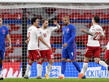 Para pemain Denmark merayakan gol yang dicetak oleh Christian Eriksen ke gawang Inggris pada laga UEFA Nations League di Stadion Wembley, Kamis (15/10/2020). Denmark menang dengan skor 1-0. (Toby Melville/Pool via AP)