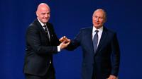 Presiden FIFA Gianni Infantino (kiri) dan Presiden Rusia Vladimir Putin (kanan) berjabat tangan di kongres FIFA untuk mencari tuan rumah Piala Dunia 2026 di Moskow, Rusia, Rabu (13/6). (AP Photo/Alexander Zemlianichenko)