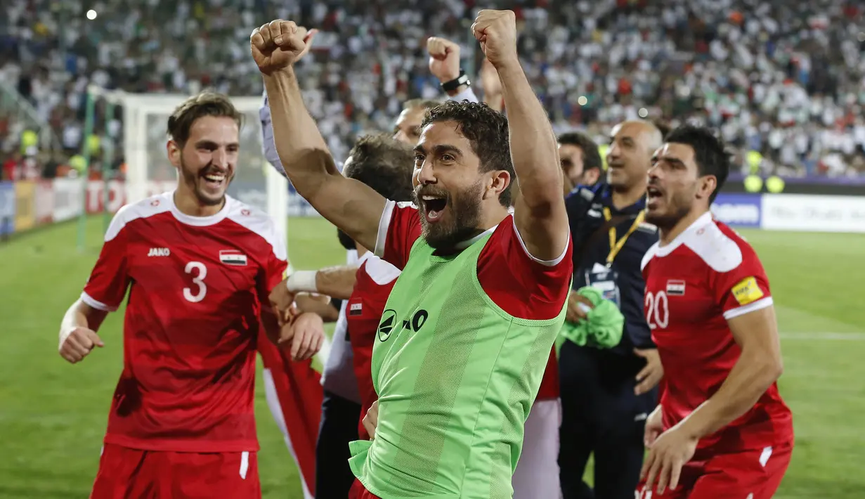 Para pemain Suriah bergembira usai menahan imbang Iran 2-2 pada laga kualifikasi Piala Dunia 2018 di Stadion Azadi, Taheran, Selasa (5/9/2017). Finis urutan tiga grup A, Suriah lolos ke babak playoff untuk menantang Australia. (AFP/Atta Kenare)