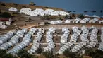 Alat berat beroperasi saat para migran berkumpul di kamp tenda sementara di Kara Tepe, Lesbos, Yunani, Kamis (17/9/2020). Lebih dari 5.000 pencari suaka kehilangan tempat tinggal sepekan setelah kebakaran menghanguskan kamp migran terbesar di Yunani, Kamp Moria. (AP Photo/Panagiotis Balaskas)
