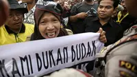 Ekspresi seorang pengunjuk rasa saat menyuarakan orasinya di depan Istana Merdeka, Jakarta, Rabu (10/2). Guru honorer dari seluruh Indonesia itu menuntut Pemerintah agar mengangkat mereka sebagai PNS (Liputan6.com/Faizal Fanani)
