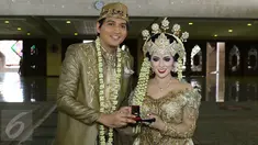 Lucky Hakim dan Tiara Dewi saat menunjukkan mahar dan cincin nikah seusai akad nikah di Masjid At Tin, Jakarta, Kamis (19/1/). Lucky Hakim dan Tiara Dewi melaksanakan akad nikah hari ini dengan mahar 500 gram logam mulia. (Liputan6.com/Herman Zakharia)