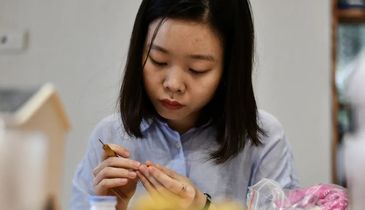 Seniman Nguyen Thi Ha An menyelesaikan pembuatan miniatur makanan di studionya, Hanoi, Vietnam, 18 Agustus 2020. Nguyen Thi Ha An melihat peluang untuk memanfaatkan kecintaan dunia yang semakin meningkat terhadap masakan Vietnam. (Manan VATSYAYANA/AFP)