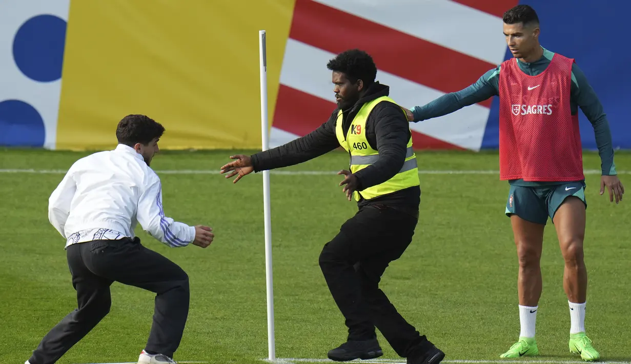 Penggemar melakukan aksi nekat dengan menerobos sesi latihan timnas Portugal demi Cristiano Ronaldo. (AP Photo/Hassan Ammar)