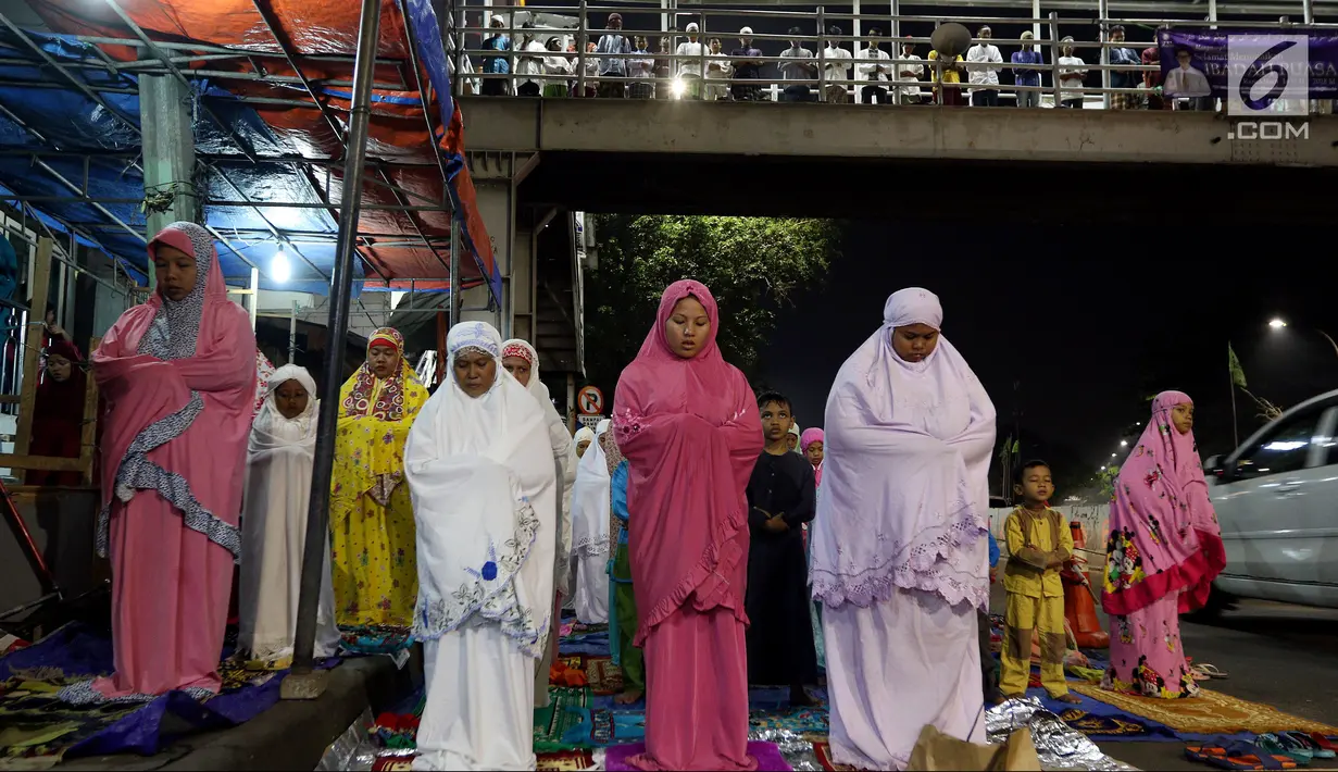 Pemandangan saat jemaah melaksanakan salat tarawih hingga ke badan jalan dan JPO akibat melubernya Musala Miftahul Jannah di Kawasan Pasar Gembrong, Jakarta, Kamis (17/5). (Liputan6.com/JohanTallo)