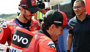 Pembalap MotoGP Spanyol dari Tim Ducati Lenovo, Marc Marquez (tengah), dan rekan setimnya dari Italia, Francesco Bagnaia (kiri), berjalan menuju pit sebelum sesi pemanasan MotoGP Grand Prix Jepang di Mobility Resort Motegi, Motegi, Prefektur Tochigi, pada 28 September 2025. (Toshifumi KITAMURA/AFP)