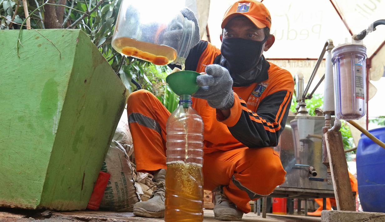 Petugas PPSU Kelurahan Kota Bambu Selatan menyaring solar hasil olahan sampah plastik di Bank Sampah Hasil Berkah, Jakarta, Kamis (11/11/2021). Sampah plastik dikonversi menjadi solar menggunakan alat mesin pirolisis untuk mengurangi pencemaran lingkungan. (Liputan6.com/Herman Zakharia)