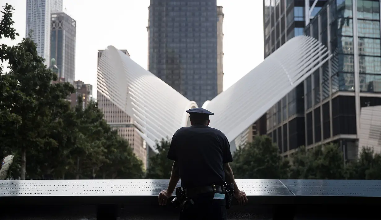 Petugas NYPD berdiri menghadiri upacara peringatan 16 tahun korban serangan 11 September di Museum dan Memorial Nasional 9/11, New York, Amerika Serikat, Senin (11/9). (Drew Angerer/Getty Images/AFP)