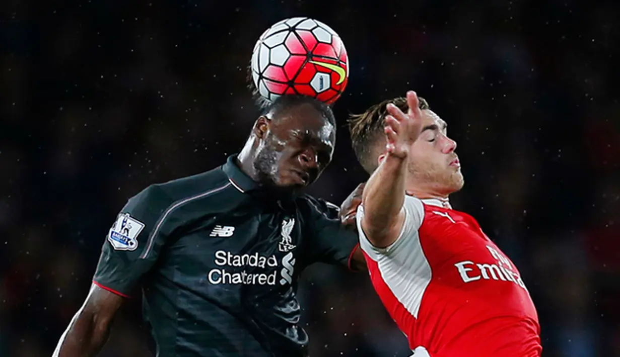 Penyerang Liverpool, Christian Benteke (kiri) berebut bola udara dengan bek Arsenal, Calum Chambers dalam pertandingan Liga Primer Inggris di Stadion Emirates, Inggris, (24/8/2015). Kedua tim bermain imbang dengan skor 0-0. (Reuters/Eddie Keogh)