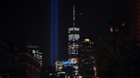 'Tribute in Light'  dinyalakan untuk memperingati serangan gedung kembar WTC yang terlihat di dekat gedung One World Trade Center, New York City, Selasa (10/9/2019). Cahaya kembar itu jadi simbol menara kembar WTC yang hancur diserang kelompok pembajak pesawat 18 tahun silam. (Johannes EISELE/AFP)