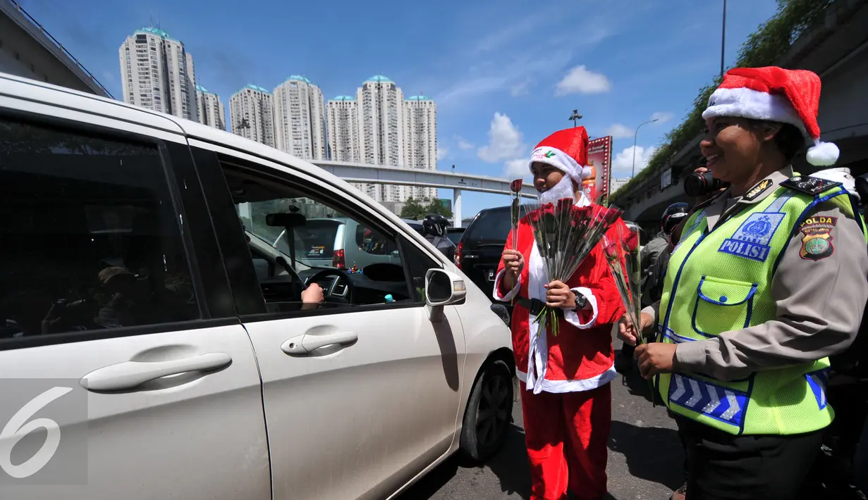 Petugas Kepolisian bersama sinterklas saat membagikan bunga dan masker di jalan kawasan Tomang, Jakarta, Rabu (23/12). Menyambut Hari Natal 2015, anggota Kepolisian Polres Jakarta Barat kenakan topi Sinterklas. (Liputan6.com/Yoppy Renato)