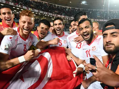 Pemain tim nasional sepak bola Tunisia melakukan selebrasi usai pertandingan melawan Libya di kualifikasi Piala Dunia 2018 di Stadion Olimpiade Rades, Tunisia (11/11). Tunisia berhasil lolos ke Piala Dunia 2018. (AFP Photo/Fethi Belaid)