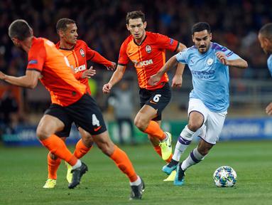 Gelandang Manchester City, Ilkay Gundogan berlari sambil membawa bola menghindari hadangan pemain Shakhtar Donetsk pada laga pertama Grup C Liga Champions di Metalist Stadium, Rabu (18/9/2019). Manchester City sukses menghantam Shakhtar Donetsk dengan skor 3-0. (AP Photo/Efrem Lukatsky)