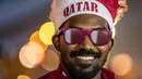 Seorang pendukung Qatar terlihat saat berkumpul dengan yang lain di luar hari pembukaan Festival Penggemar FIFA di taman Al Bidda di Doha pada 20 November 2022, saat pembukaan turnamen Piala Dunia Qatar 2022. (AFP/Philip Fong)
