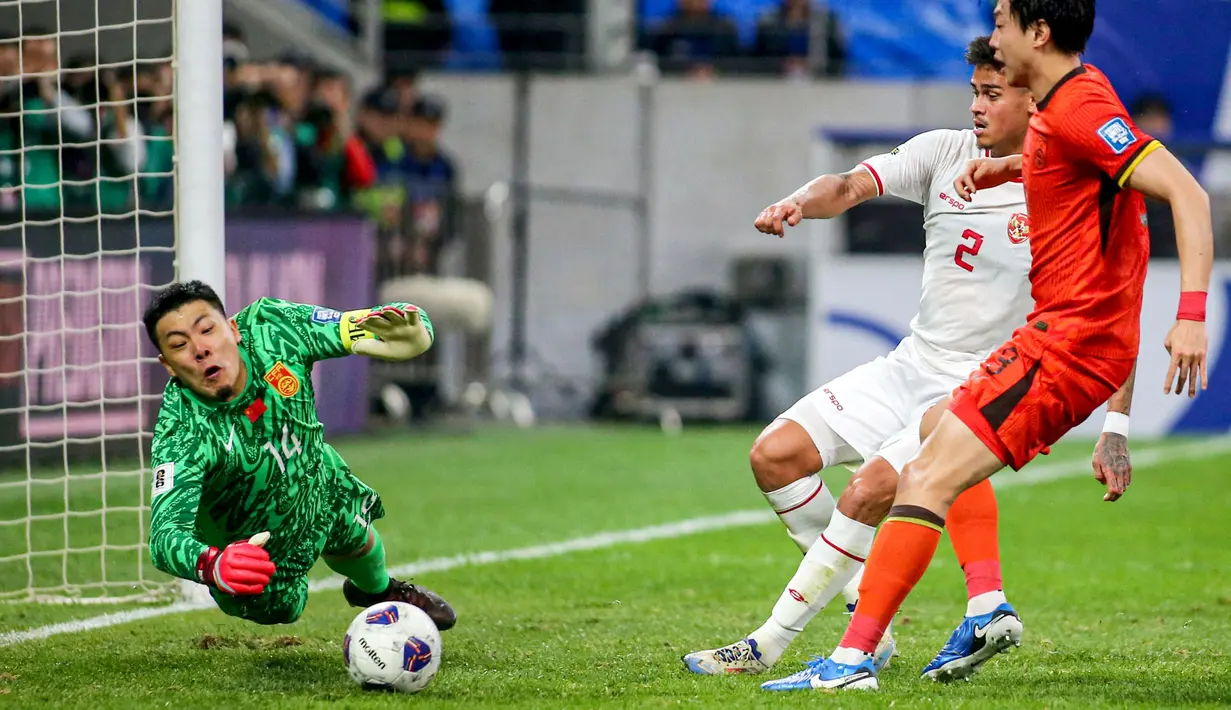 Pemain Timnas Indonesia, Mees Hilgers (tengah) berusaha mencetak gol ke gawang China yang dijaga oleh Wang Dalei saat laga lanjutan putaran ketiga Grup C Kualifikasi Piala Dunia 2026 di Qingdao Youth Stadium, Qingdao, China, Selasa (15/10/2024). (AFP)
