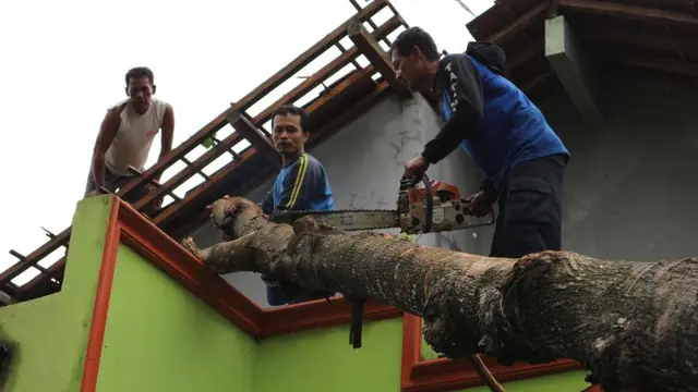 Batang pohon yang besar menyebabkan relawan kesulitan menyingkirkannya dari atap rumah penduduk. (Foto: Liputan6.com/BPBD BMS/Muhamad Ridlo)