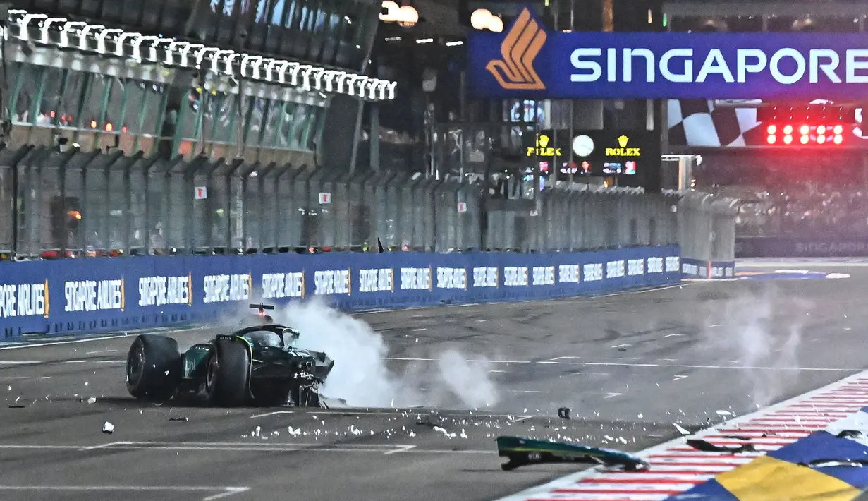 Mobil pembalap Aston Martin, Lance Stroll mengeluarkan asap setelah menabrak dinding lintasan saat sesi Kualifikasi 1 (Q1) Formula 1 GP Singapura 2023 yang berlangsung di Sirkuit Marina Bay, Singapura, Sabtu (16/03/2023). Kekuatan tumbukan tersebut meremukkan sepenuhnya roda kiri depannya dan sejumlah besar sasis di sisi mobil tersebut. (AFP/Lillian Suwanrumpha)