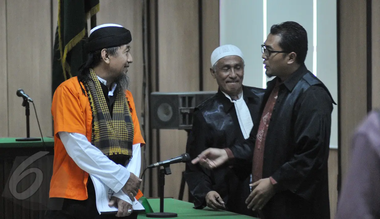 Terdakwa kasus terorisme Afif Abdul Majid berdiskusi dengan tim kuasa hukumnya saat sidang tuntutan di Pengadilan Negeri Jakarta Pusat, Senin (8/6/2015). (Liputan6.com/Herman Zakharia)