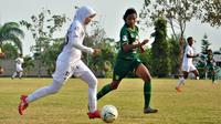 Gelandang tim putri Arema, Risky Rahmadani, diadang pemain Persebaya dalam laga Liga 1 Putri 2019 di Arhanud, Karangploso, Kabupaten Malang (7/10/2019). (Bola.com/Iwan Setiawan).